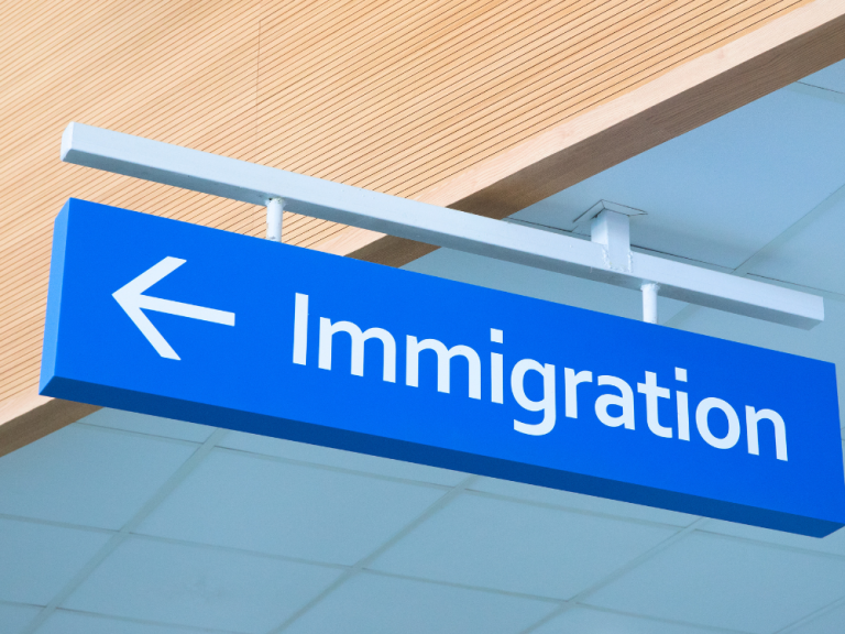 Directional sign with an arrow pointing toward immigration